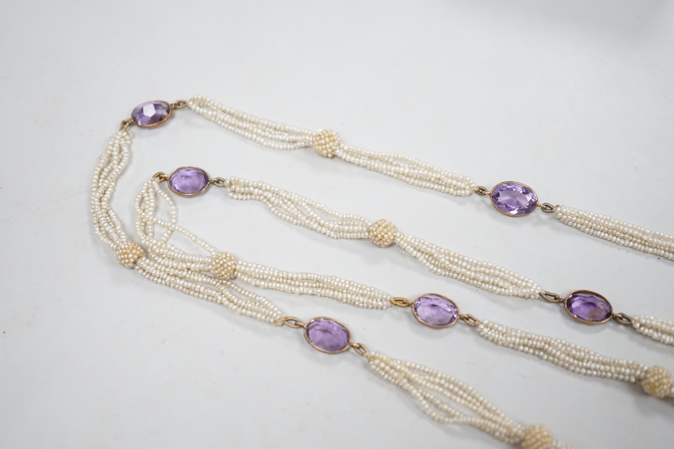 A 19th century Indian multi strand seed pearl and oval cut amethyst set long necklace, with gem set tassel drops, 166cm.
